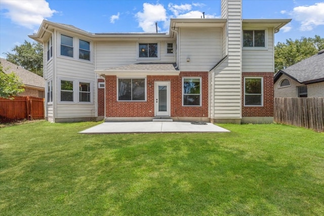 back of property with a patio area and a lawn