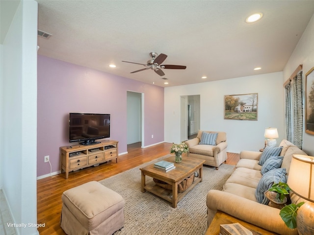 living room featuring hardwood / wood-style floors and ceiling fan