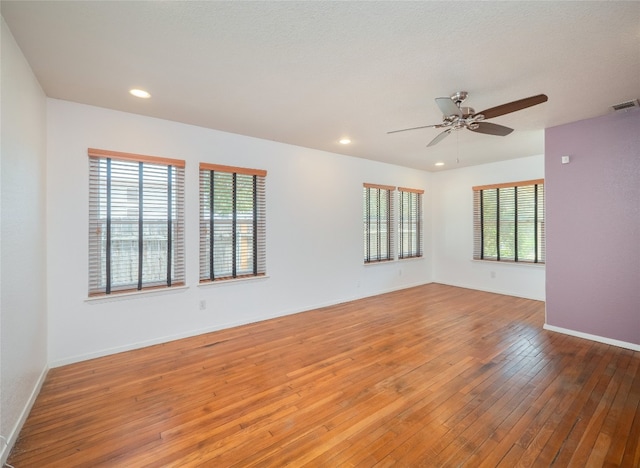 unfurnished room with hardwood / wood-style floors, plenty of natural light, and ceiling fan