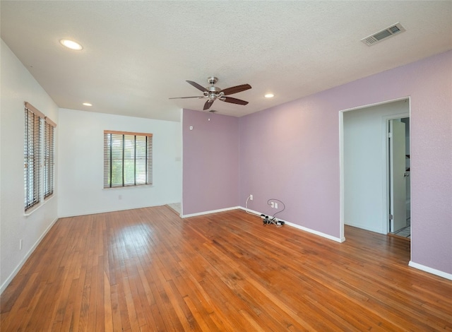 unfurnished room with a textured ceiling, hardwood / wood-style flooring, and ceiling fan