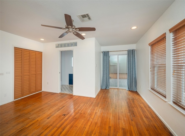 unfurnished bedroom featuring a closet, light wood-type flooring, and ceiling fan