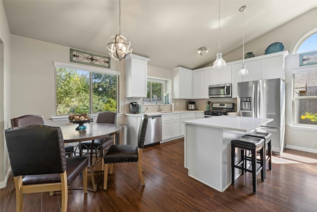 kitchen featuring appliances with stainless steel finishes, a healthy amount of sunlight, and pendant lighting