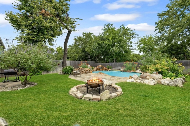 view of yard with an outdoor fire pit and a fenced in pool