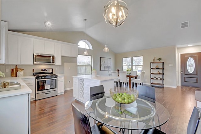 dining room with a notable chandelier, high vaulted ceiling, and dark hardwood / wood-style flooring