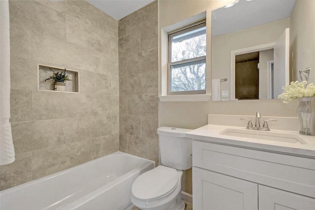 full bathroom featuring tiled shower / bath, vanity, and toilet