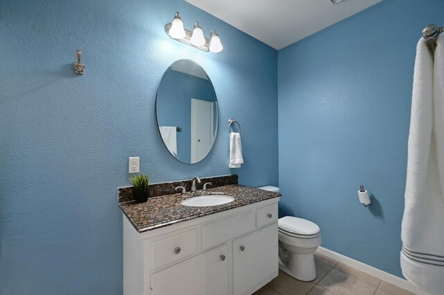 bathroom featuring vanity, toilet, and tile patterned floors