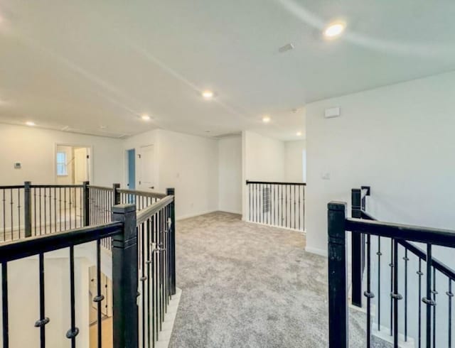 hall featuring recessed lighting, baseboards, light colored carpet, and an upstairs landing