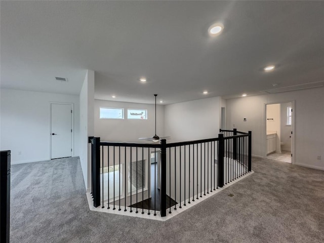 corridor with an upstairs landing, visible vents, recessed lighting, and carpet