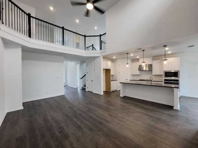 unfurnished living room featuring dark wood-type flooring, stairway, recessed lighting, and ceiling fan