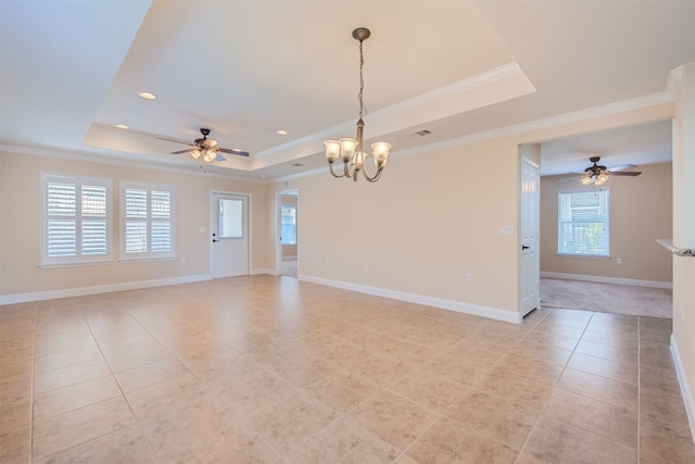 tiled empty room featuring a tray ceiling, ceiling fan with notable chandelier, and ornamental molding