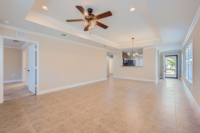 unfurnished living room featuring a tray ceiling, ceiling fan with notable chandelier, and ornamental molding