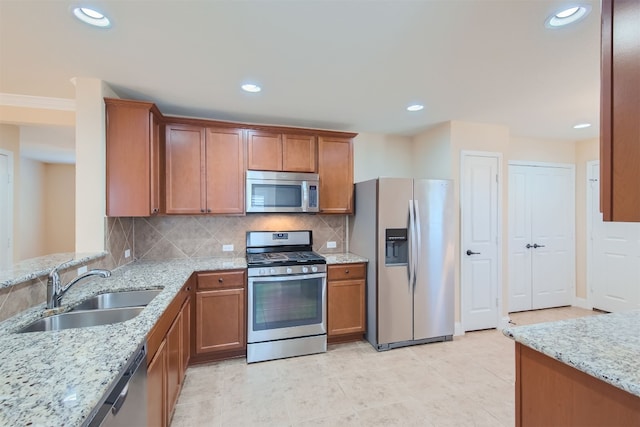 kitchen with light stone countertops, sink, stainless steel appliances, backsplash, and light tile patterned floors