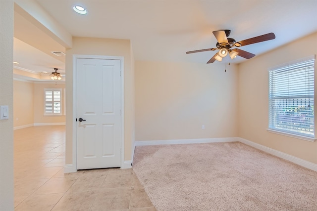 carpeted empty room featuring ceiling fan and a wealth of natural light