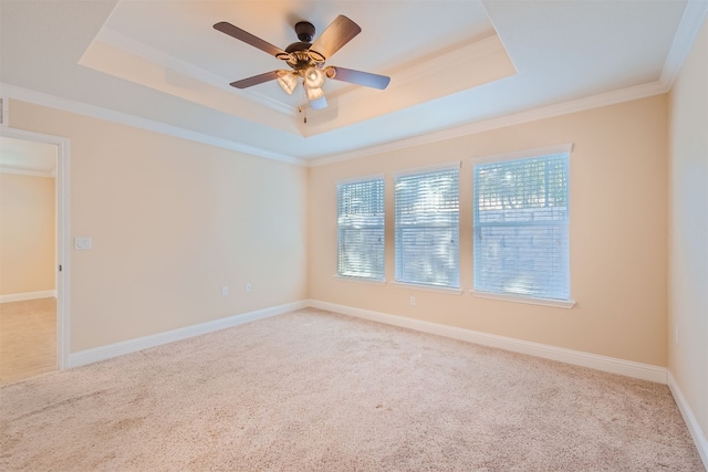 unfurnished room with ceiling fan, crown molding, light carpet, and a tray ceiling