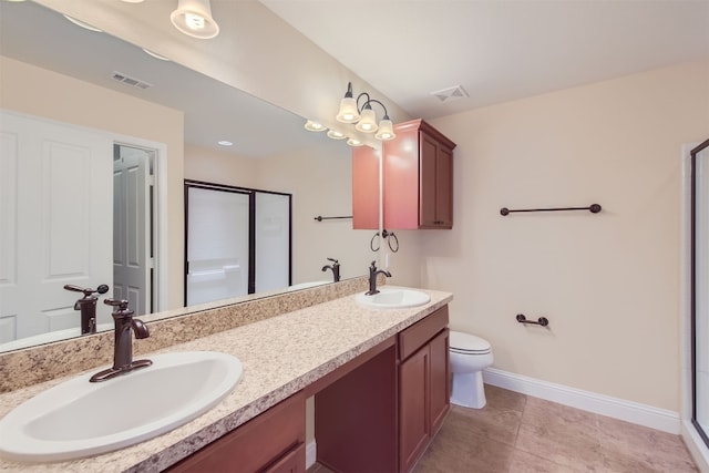 bathroom with tile patterned flooring, vanity, toilet, and a shower with shower door