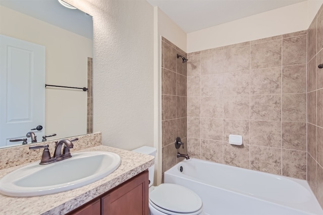 full bathroom featuring toilet, vanity, and tiled shower / bath