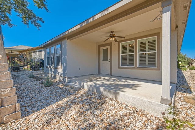 doorway to property with ceiling fan and a patio area