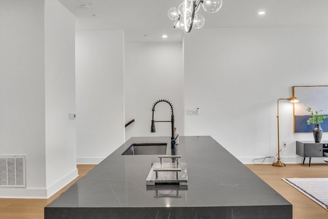 kitchen featuring sink, light hardwood / wood-style flooring, and pendant lighting