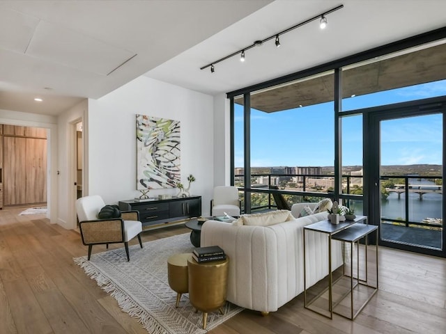 70 Rainey St Unit 1408, Austin, TX 78701 - living area with a wall of windows, rail lighting, and wood finished floors