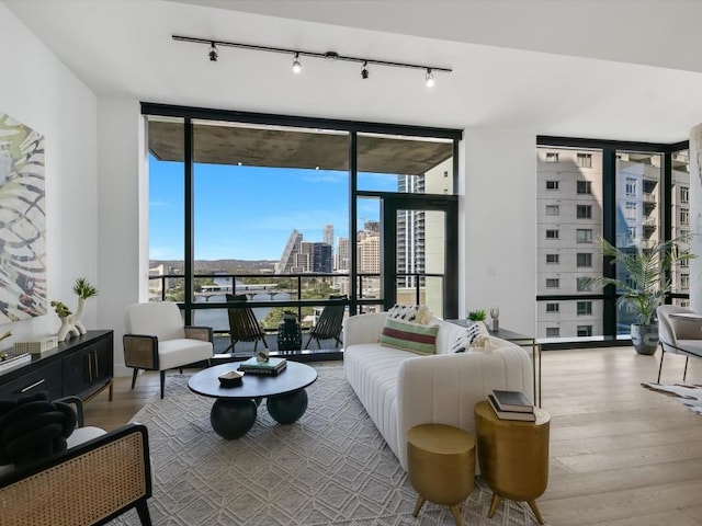70 Rainey St Unit 1408, Austin, TX 78701 - living area with a wall of windows, track lighting, wood finished floors, and a view of city