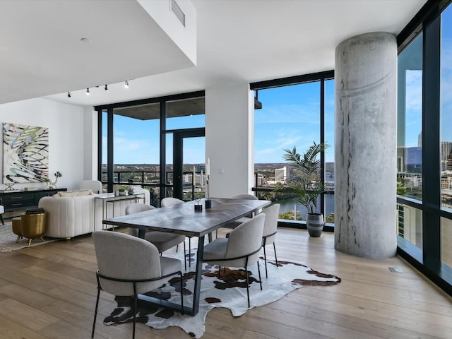 70 Rainey St Unit 1408, Austin, TX 78701 - dining space with a wall of windows, hardwood / wood-style floors, a water view, and track lighting