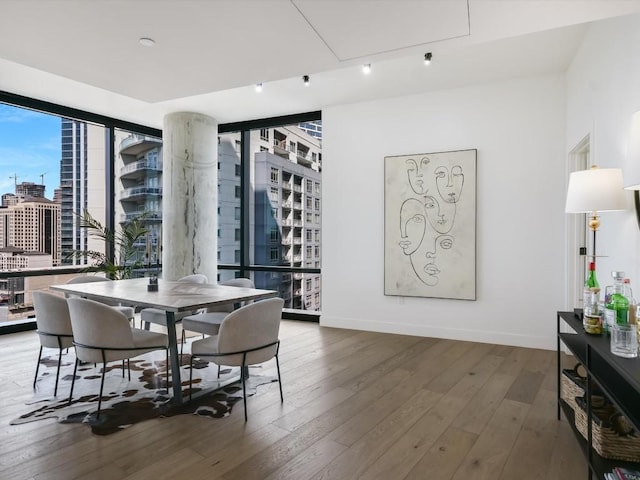 70 Rainey St Unit 1408, Austin, TX 78701 - dining space featuring a city view, hardwood / wood-style flooring, floor to ceiling windows, and baseboards