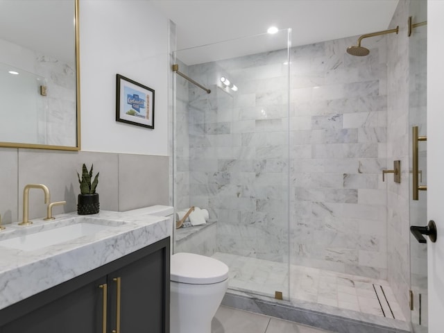 bathroom featuring vanity, toilet, tile walls, and walk in shower