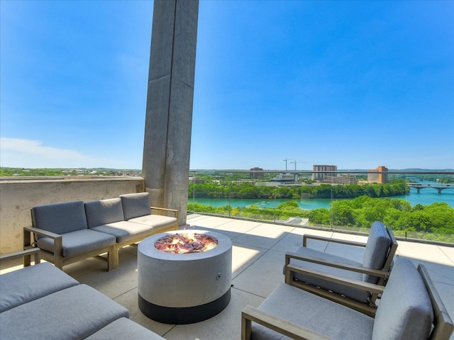 view of patio / terrace with a water view and an outdoor living space with a fire pit