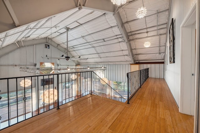 hall featuring vaulted ceiling with beams, hardwood / wood-style flooring, and wood walls