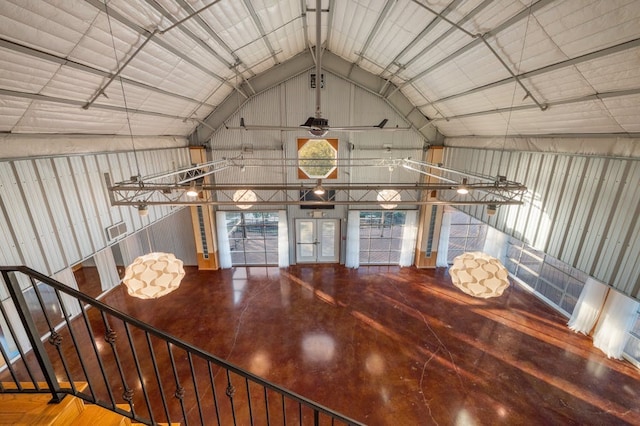 unfurnished dining area featuring wooden walls, high vaulted ceiling, and hardwood / wood-style flooring