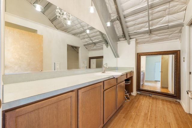 interior space with pendant lighting, light hardwood / wood-style floors, and sink