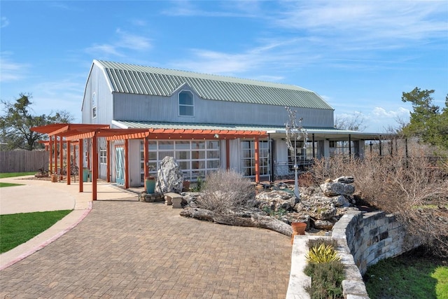 view of front of property with metal roof and fence