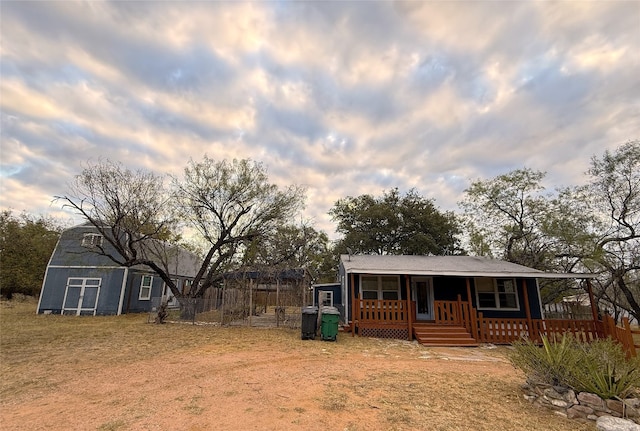 view of front of house featuring a storage shed and covered porch