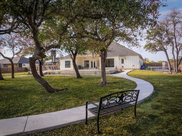 view of property's community with a lawn and fence
