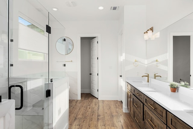 bathroom with a shower with door, wood-type flooring, and vanity