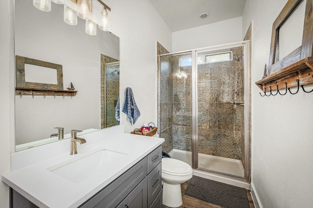 bathroom with a shower with door, vanity, hardwood / wood-style flooring, and toilet