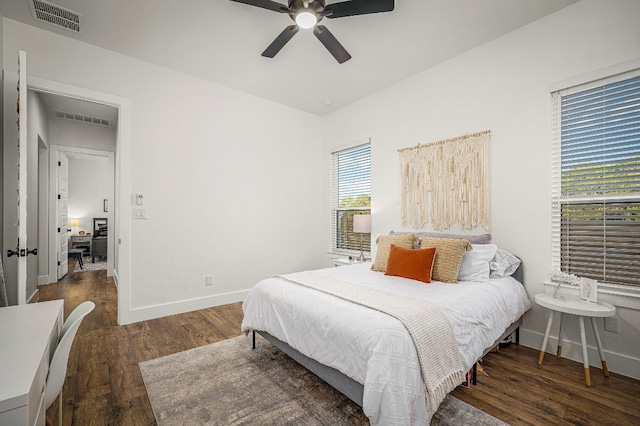 bedroom featuring visible vents, a ceiling fan, baseboards, and wood finished floors
