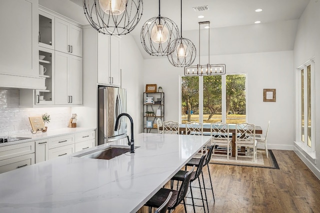 kitchen featuring dark wood-style flooring, an inviting chandelier, a sink, freestanding refrigerator, and visible vents