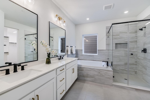 bathroom featuring tile patterned floors, vanity, and shower with separate bathtub