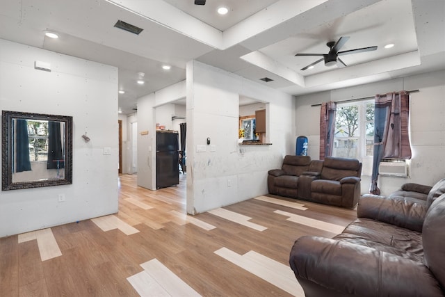 living room featuring ceiling fan, a raised ceiling, cooling unit, and light wood-type flooring