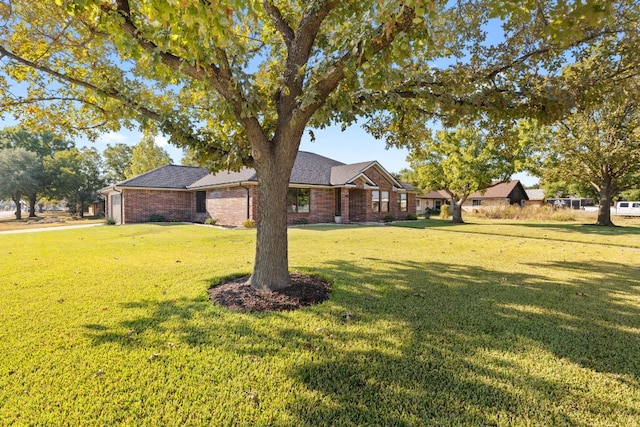 view of front facade with brick siding and a front lawn