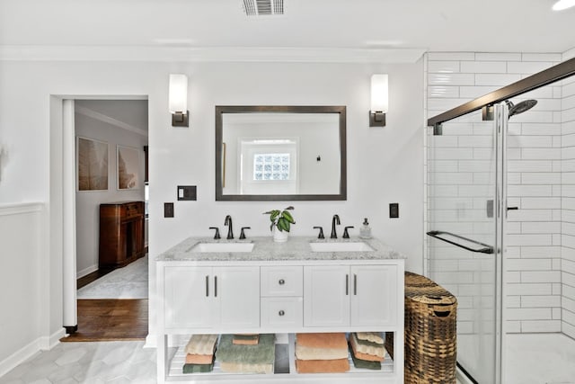 bathroom featuring vanity, ornamental molding, and a shower with shower door