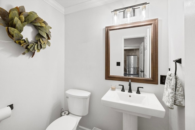 bathroom featuring crown molding, a sink, and toilet