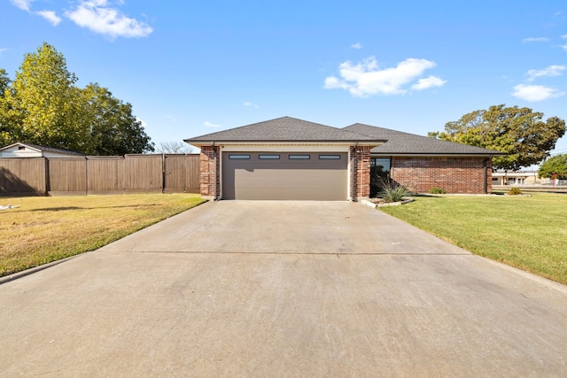 view of front of house featuring fence, brick siding, a garage, a front yard, and driveway