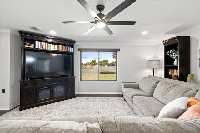 living area featuring a ceiling fan, visible vents, crown molding, wood finished floors, and baseboards