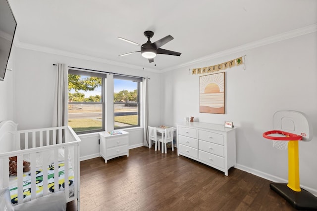 bedroom featuring crown molding, a nursery area, ceiling fan, and dark hardwood / wood-style flooring