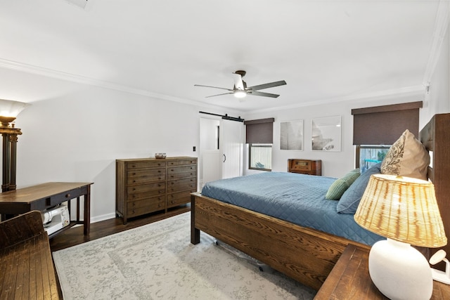 bedroom with ceiling fan, ornamental molding, dark hardwood / wood-style flooring, and a barn door