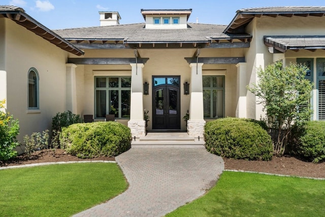 doorway to property featuring french doors and a lawn