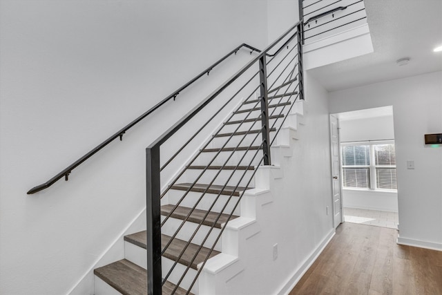 stairs featuring hardwood / wood-style floors