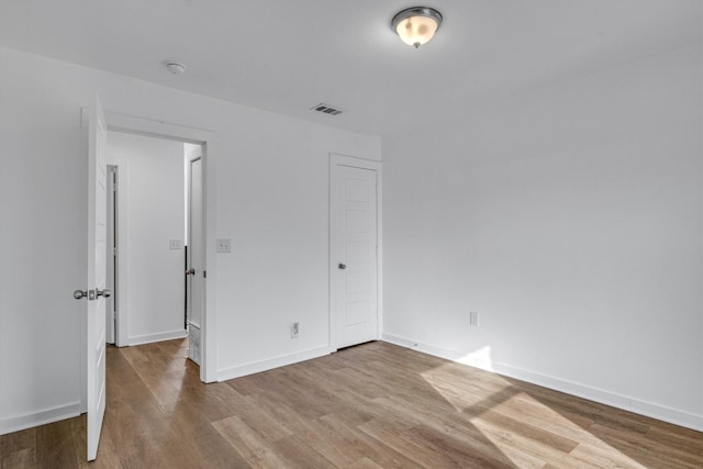 unfurnished bedroom with a closet and light hardwood / wood-style floors